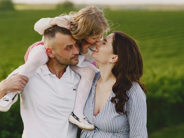 A delightful family moment captured in a lush scenic field, portraying love and happiness.